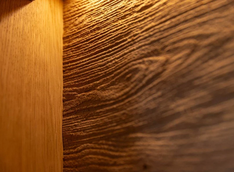 Beleuchtete Standvitrine aus massiver Eiche mit Hirnholz | Wohnzimmerschrank Tirano III mit Rückwand in grober Holzstruktur