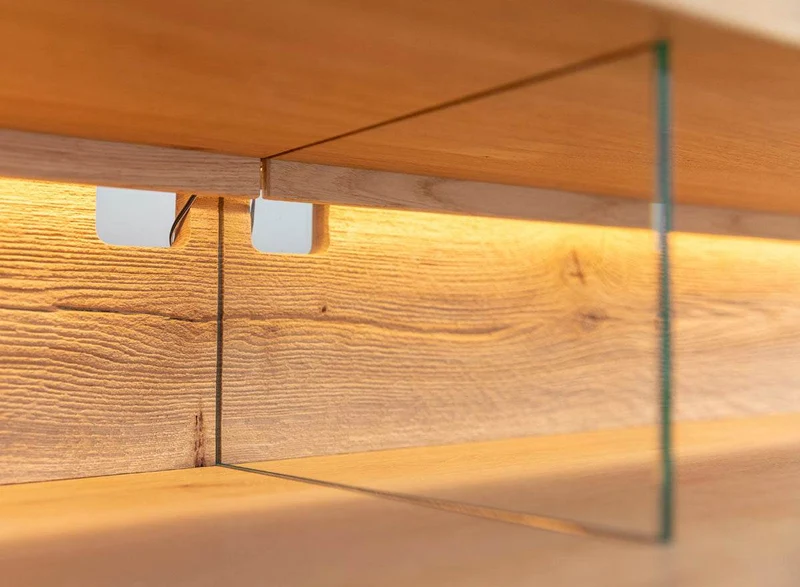 Beleuchtete Hängekommode aus massiver Eiche mit Lamellen | TV-Board Tirano II mit Schaukasten und grober Holzstruktur