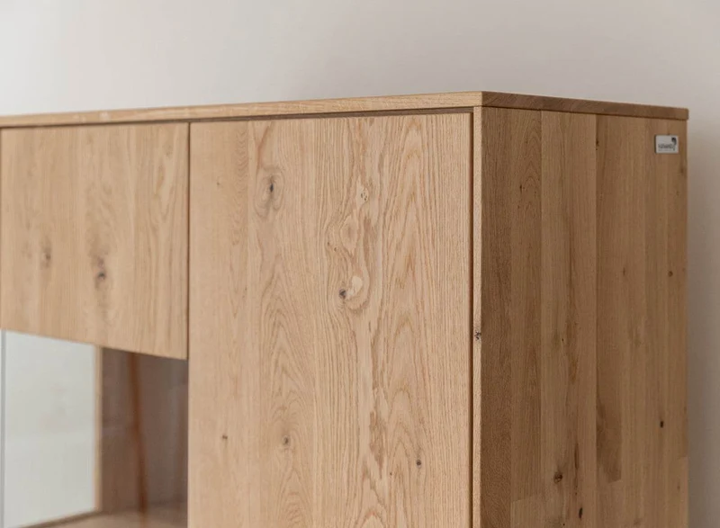 Beleuchtete Standvitrine aus massiver Eiche mit Lamellen | Wohnzimmerschrank Tirano II mit Rückwand in grober Holzstruktur