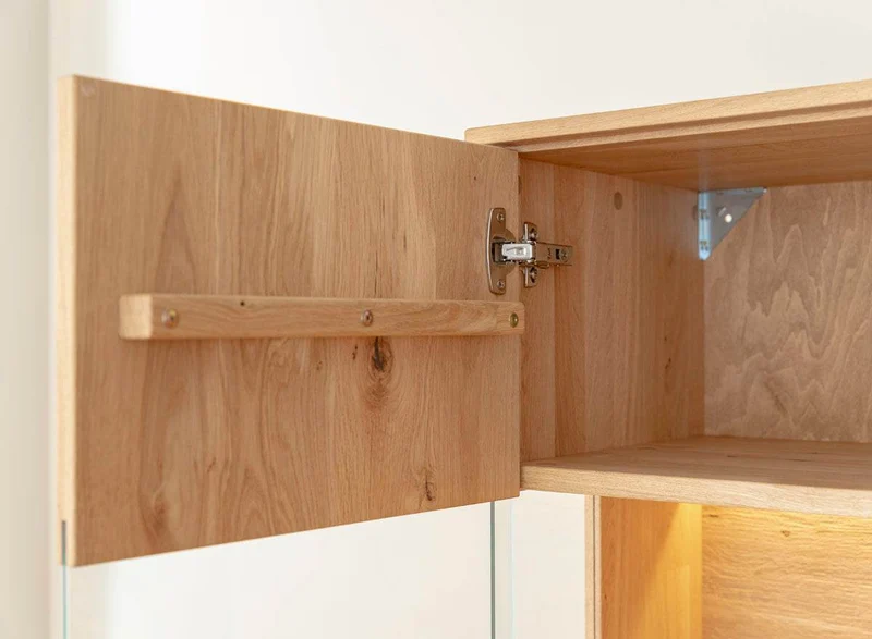 Beleuchtete Standvitrine aus massiver Eiche mit Lamellen | Wohnzimmerschrank Tirano II mit Rückwand in grober Holzstruktur
