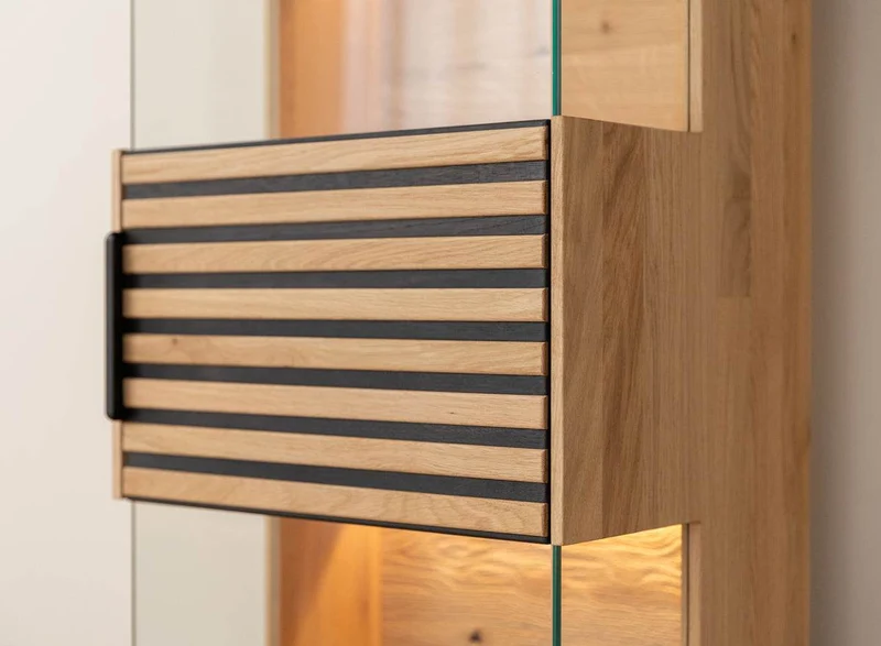Beleuchtete Hängevitrine aus massiver Eiche mit Lamellen | Vitrine Tirano II mit Rückwand in grober Holzstruktur