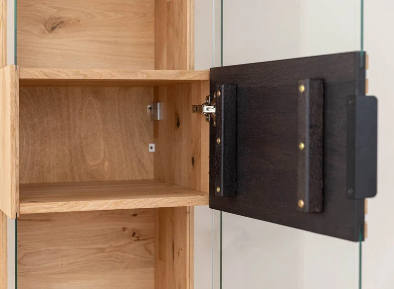 Beleuchtete Hängevitrine aus massiver Eiche mit Lamellen | Vitrine Tirano II mit Rückwand in grober Holzstruktur