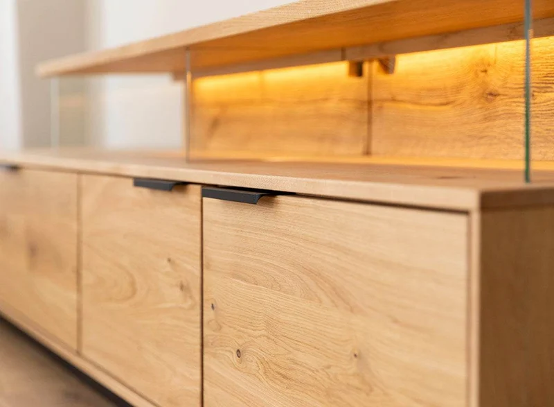 Beleuchtete Hängekommode aus massiver Eiche | TV-Board Tirano I mit Schaukasten und grober Holzstruktur