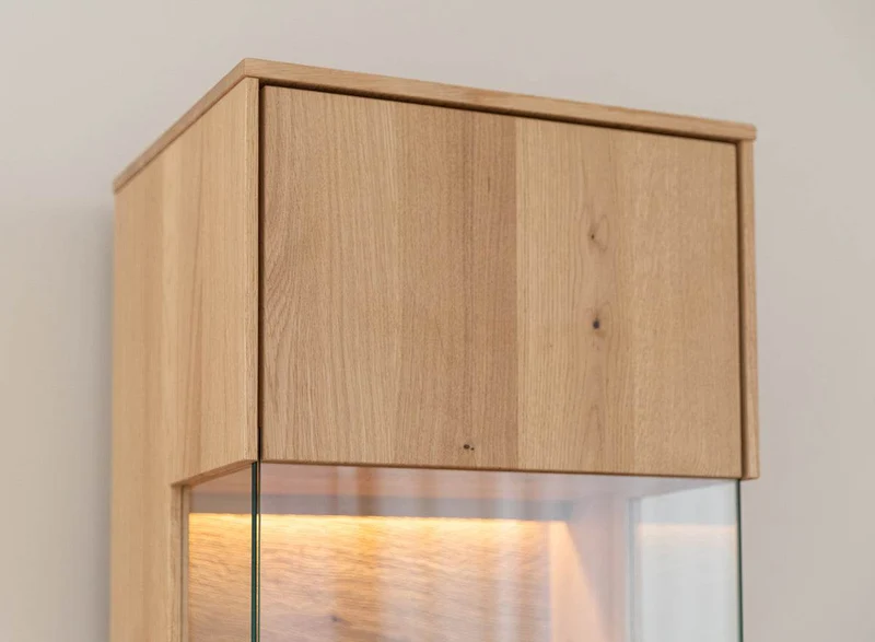 Beleuchtete Standvitrine aus massiver Eiche | Vitrine Tirano I mit Rückwand in grober Holzstruktur
