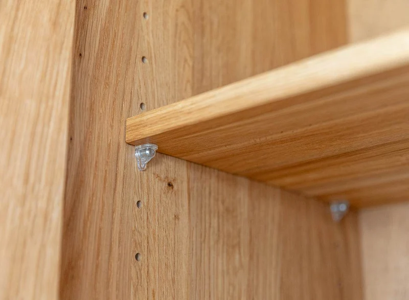 Beleuchteter Wohnzimmerschrank Collodi aus massiver Wildeiche mit Rückwand in grober Holzstruktur