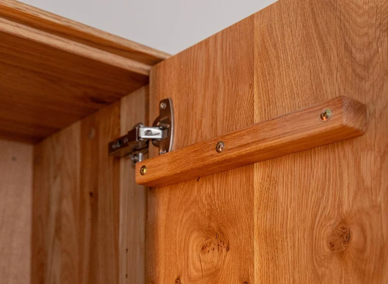 Beleuchteter Wohnzimmerschrank Collodi aus massiver Wildeiche mit Rückwand in grober Holzstruktur
